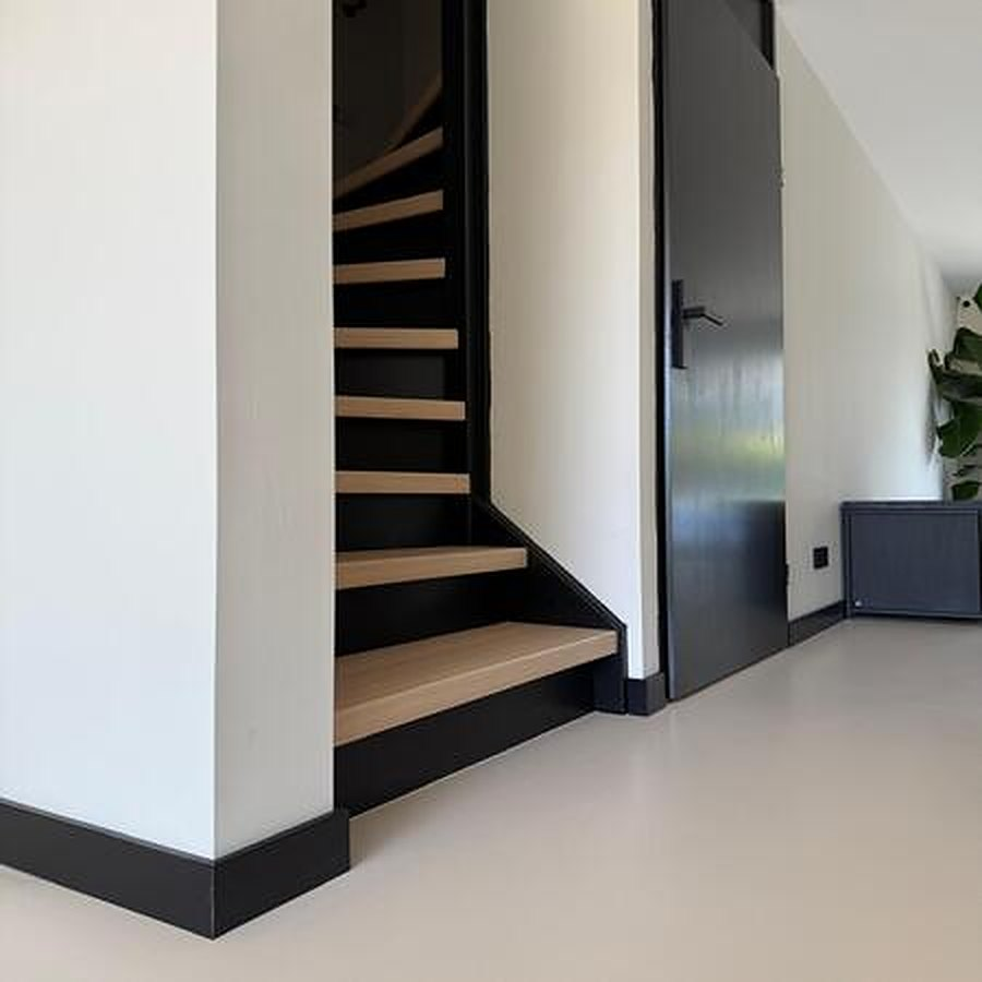 Lavasteen gietvloer met zwarte plinten langs de trap
